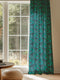 A sheer curtain panel in emerald green featuring a repeating pattern of raven silhouettes and Victorian botanical fan motifs. The fabric has a semi-transparent, linen-like texture.